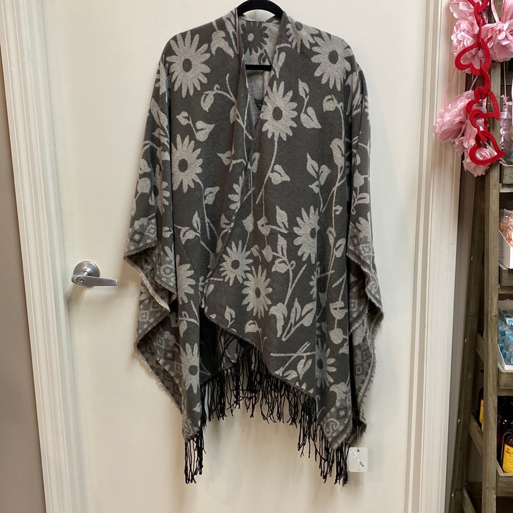Reversible gray cape with black fringe at bottom.